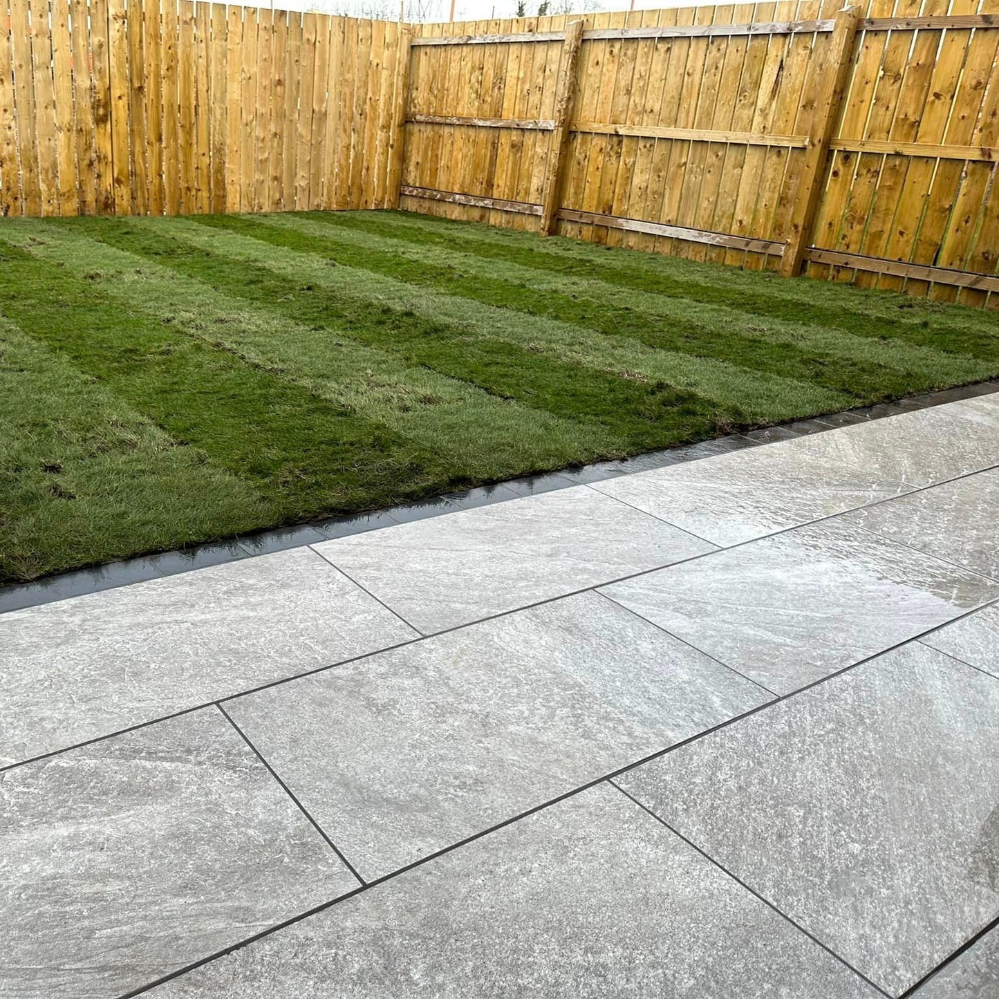 Patio area and garden featuring Grey Twice Qz Range Porcelain Paving Tiles.