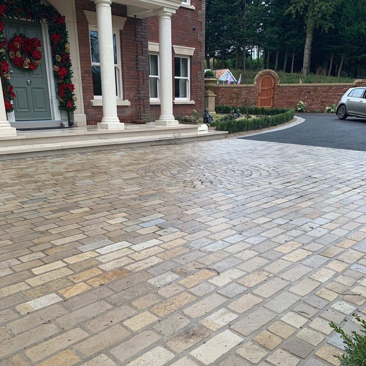 Paved driveway using Mountcharles Sandstone Paving Setts leading to a house with decorative wreaths on the door.