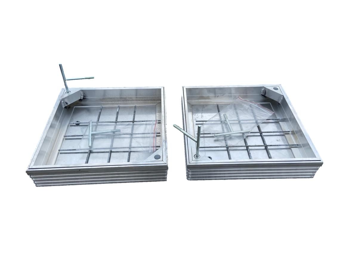 Two recessed manhole covers side by side.