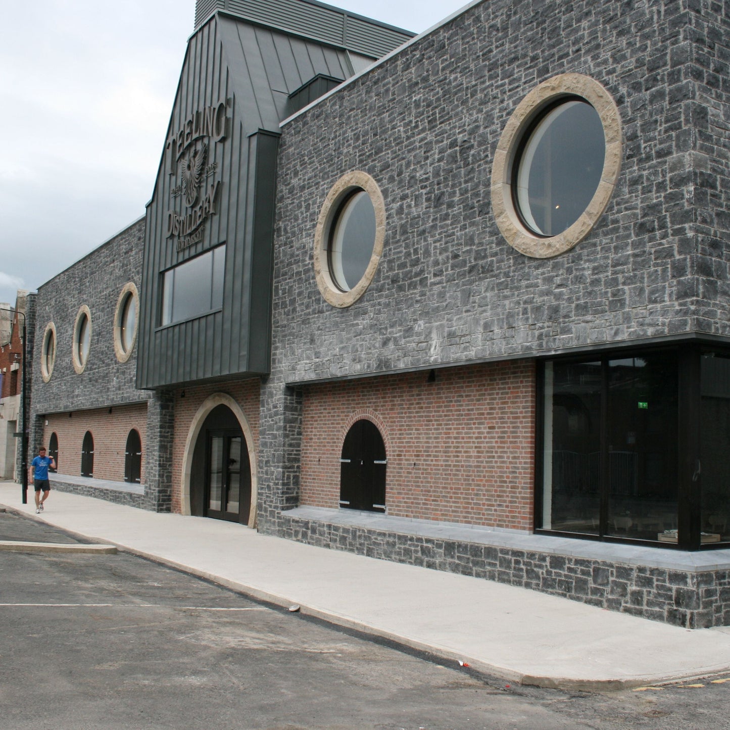 Modern building with circular sandstone window surrounds on a cloudy day