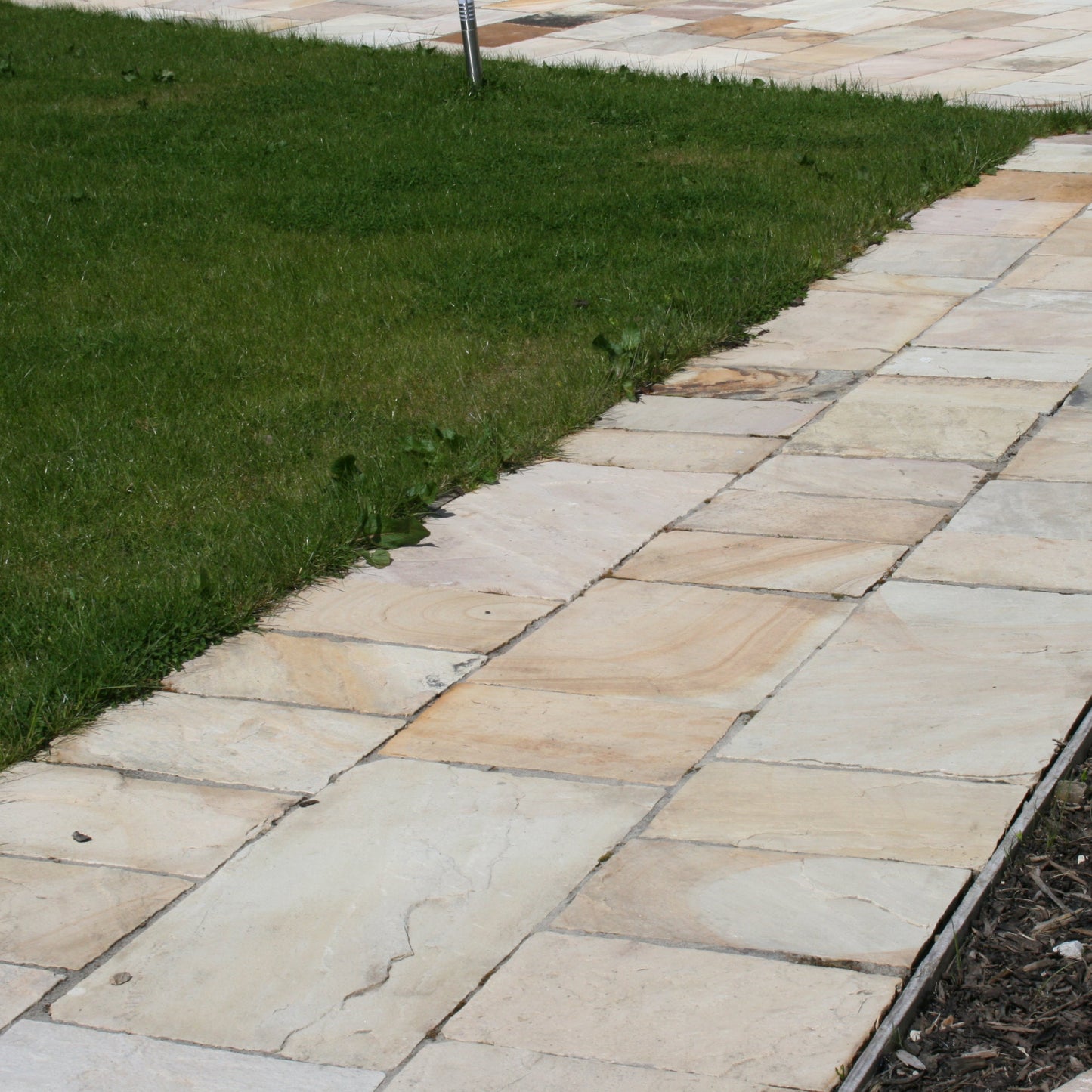 Close up of Tinted Mint Sandstone Paving to show 900 x 600 slab size and colour variations.
