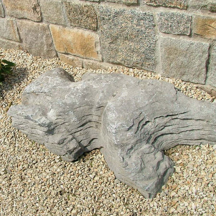Rockery area featuring waterworn limestone karst stones against a stone wall.