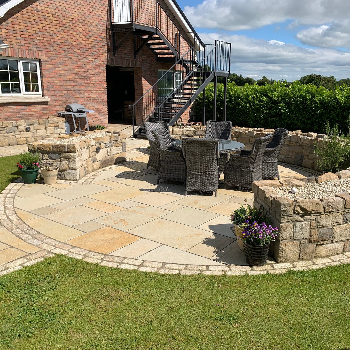 Circular stone seating area featuring stone walling and Yellow Limestone Tumbled Paving and Gold Granite Cobbles.