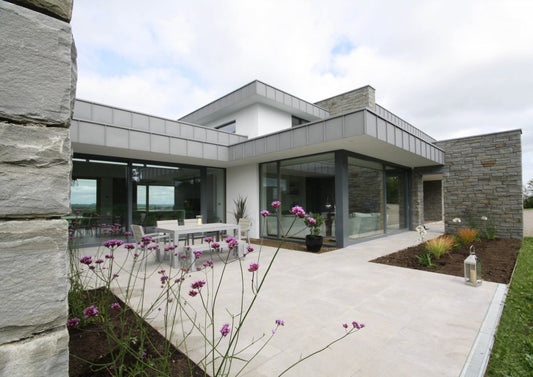 The Wall House featuring Grey Sandstone Machined Walling Stone, Architectural Blue Limestone Wall Capping, and Moov Grey Porcelain Tiles