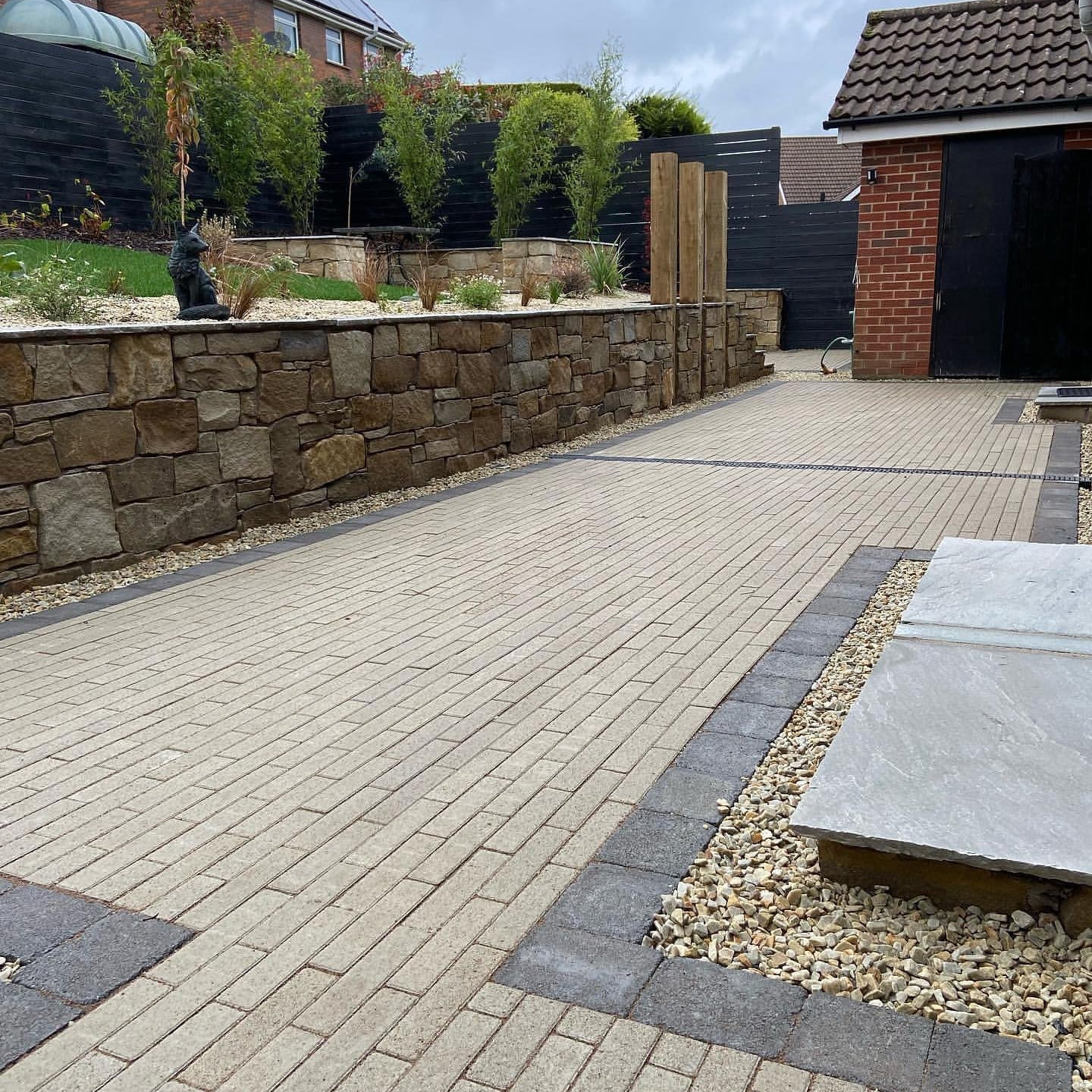 Paved garden area with stone wall and garden features, featuring patio border of 10mm Gold Donegal Quartzite Stone Chipping. 
