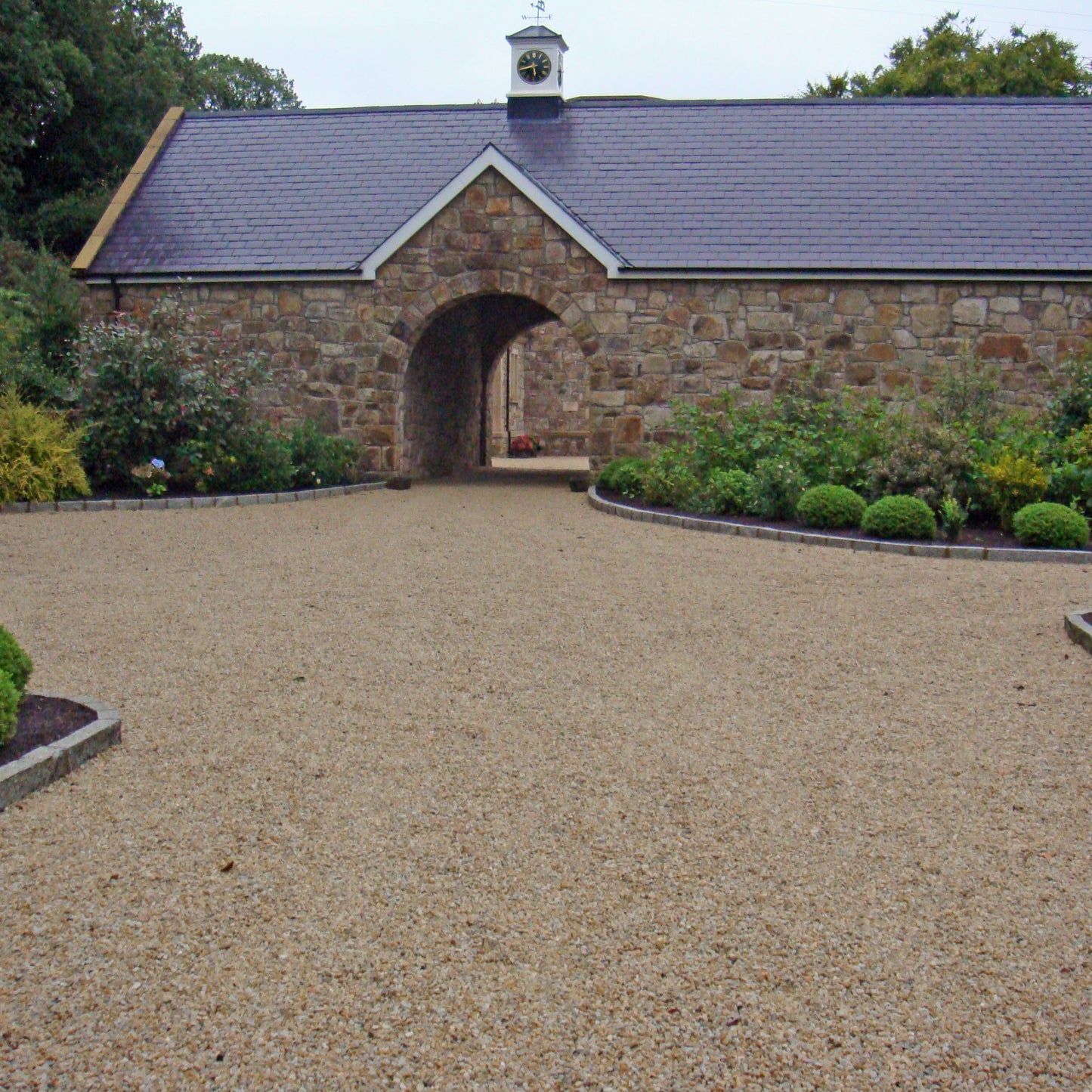 Stone building with a gravel driveway leading up to it. Completed using 14mm Gold Donegal Quartzite Stone Chipping.
