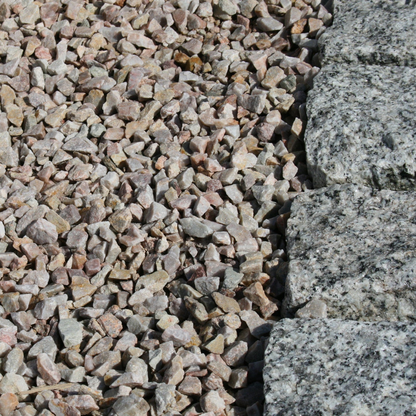 Close up of 
14mm Rose Gold Quartzite Stone Chipping beside Silver Granite Cobbles. 