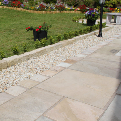 Garden and patio area with decorative patio edging featuring 20mm Gold Donegal Quartzite Stone Chipping. 