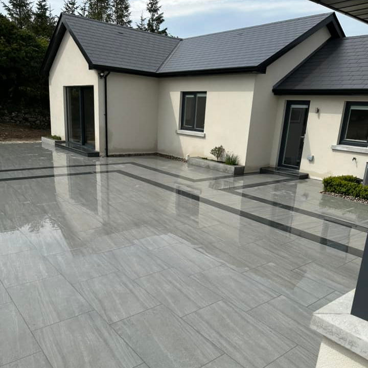 Large patio area featuring Ashen porcelain paving tiles in 900 x 600 x 20mm size. 