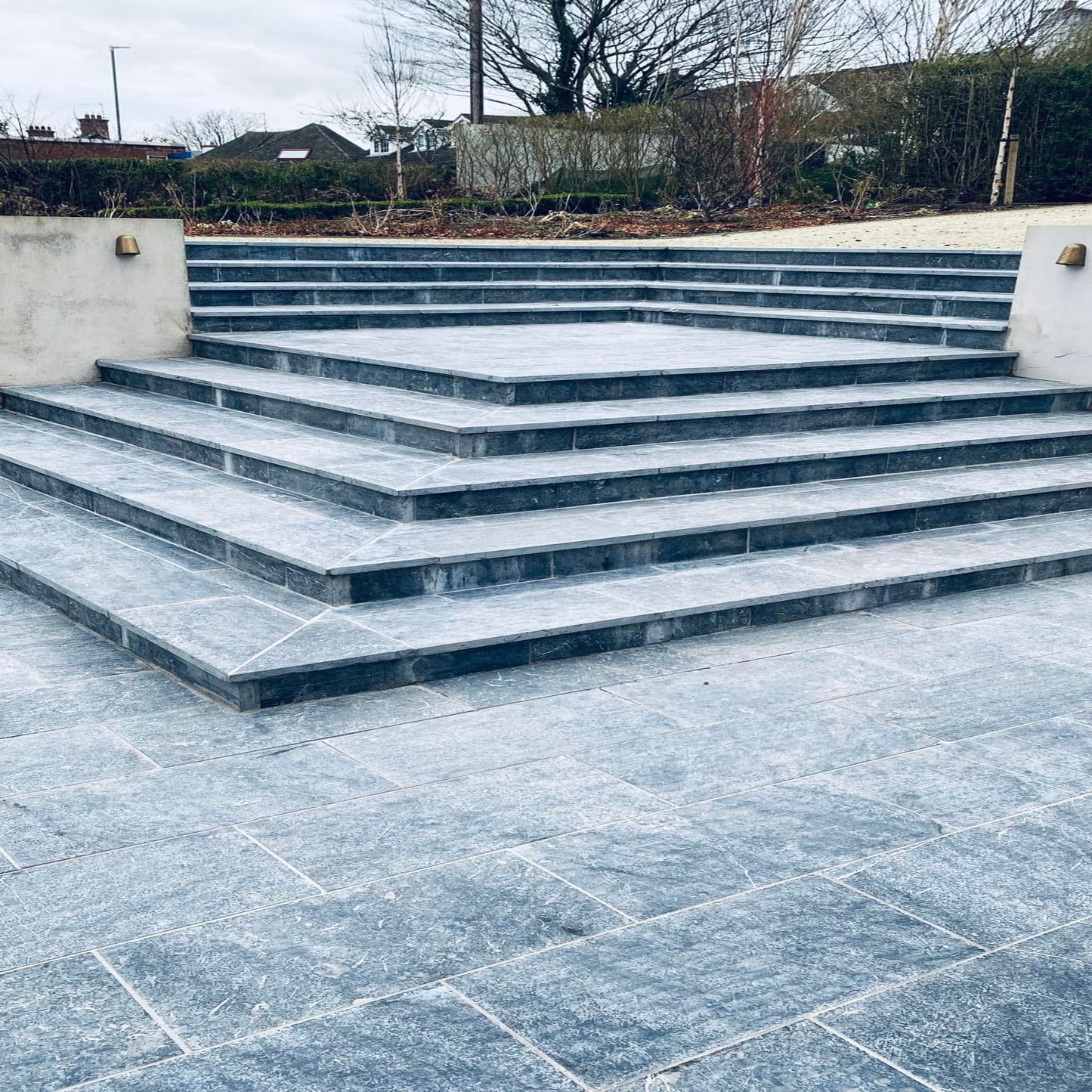 Bespoke Blue Limestone Steps leading up to a garden area with a concrete wall.