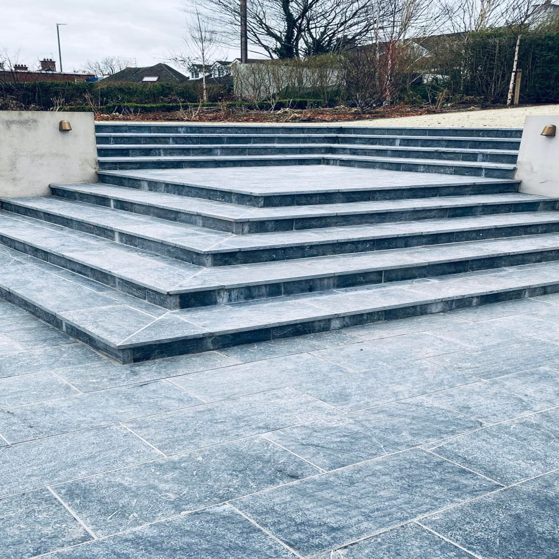 Bespoke Blue Limestone Steps leading up to a garden area with a concrete wall.