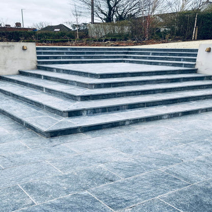 Bespoke Blue Limestone Steps leading up to a garden area with a concrete wall.