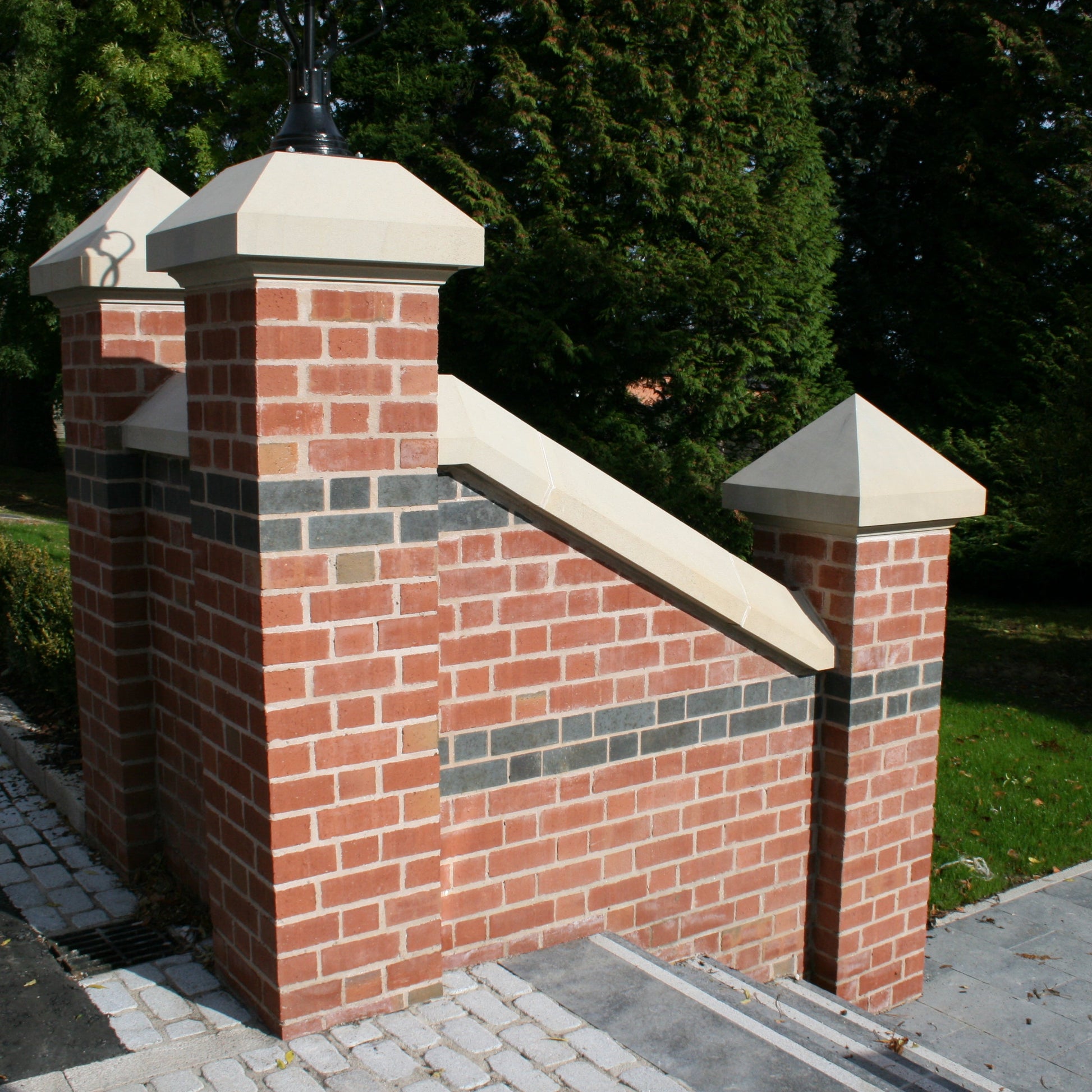 Red brick wall with bespoke sandstone wall and pillar capping. 