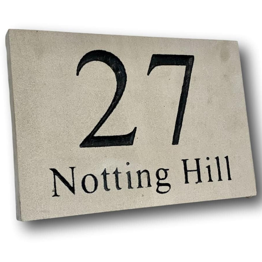A rectangular sandstone plaque with the number 27 and the text 'Notting Hill' engraved in a classic font.