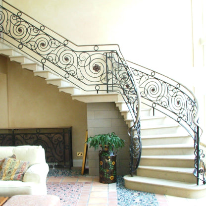 Decorative sandstone staircase with ornate railings in a home interior.