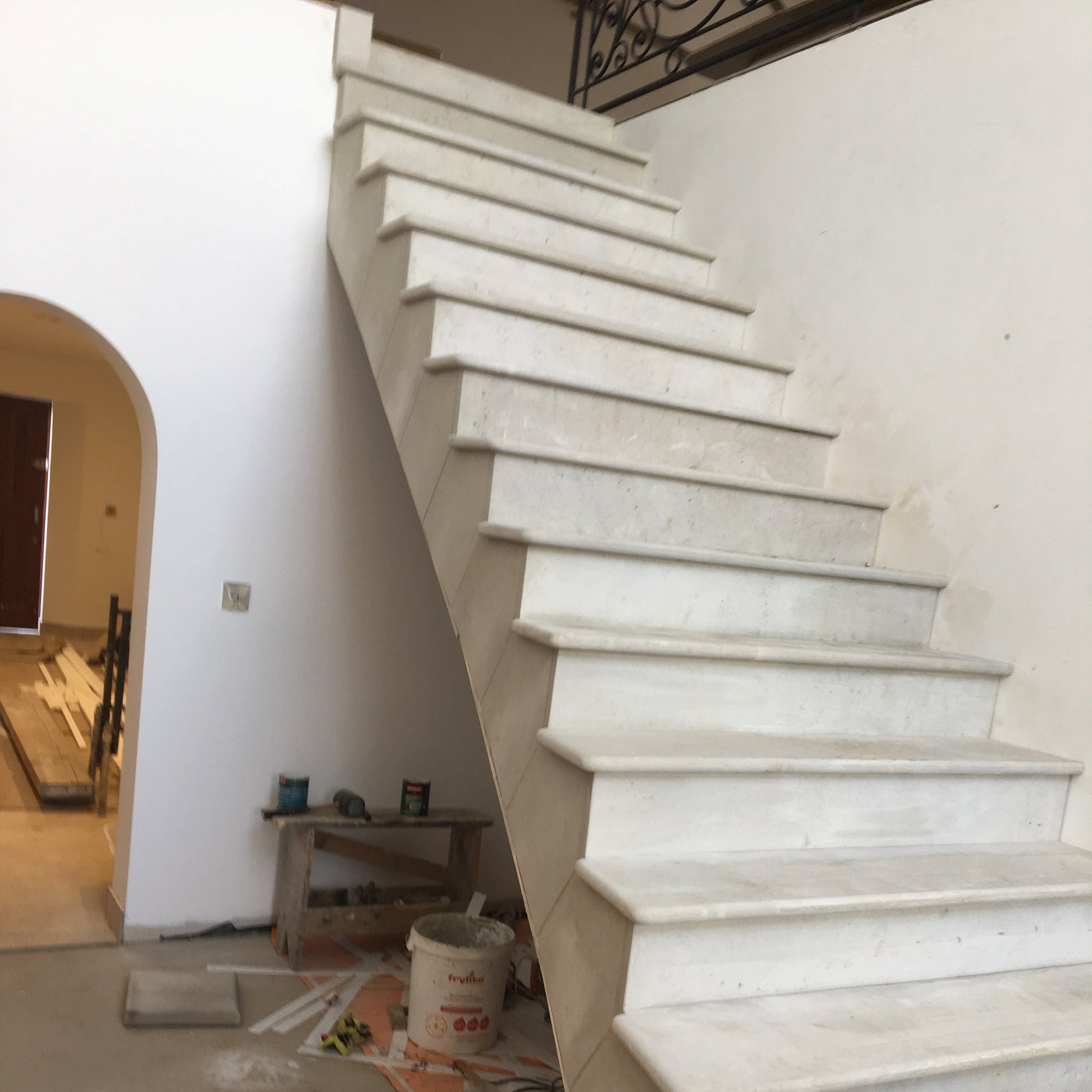 Under construction sandstone staircase with tools and materials on the floor.