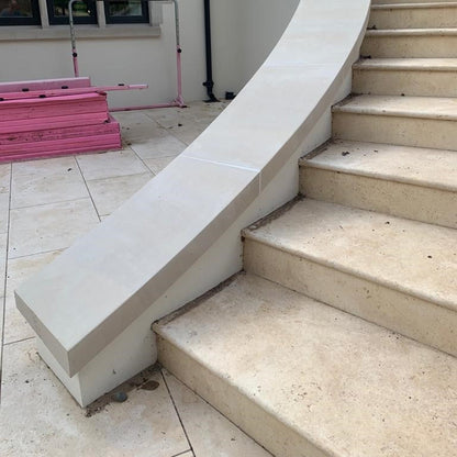 Bespoke curved external sandstone staircase with bullnose edging and matching wall capping. 