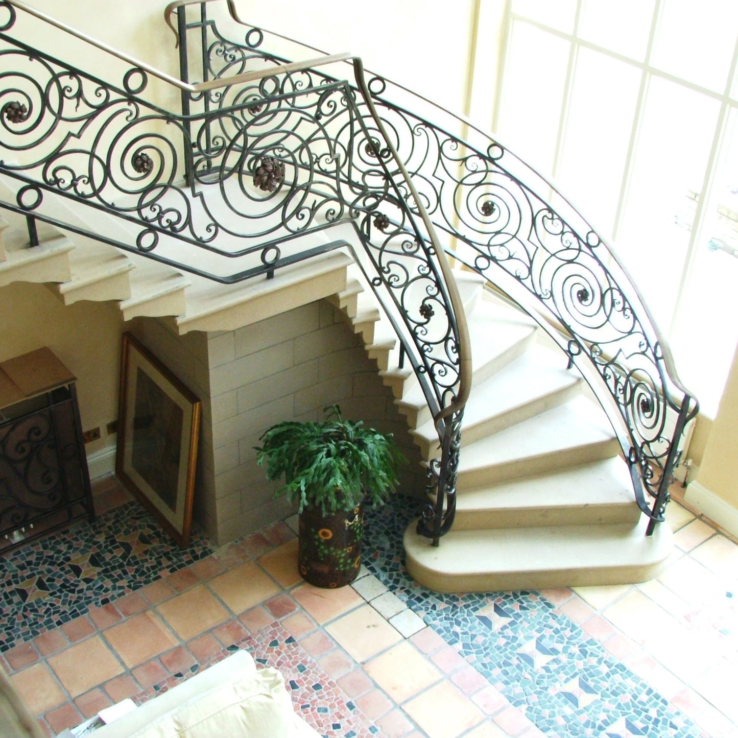 Decorative Sandstone Staircase with wrought iron railing in a home interior.