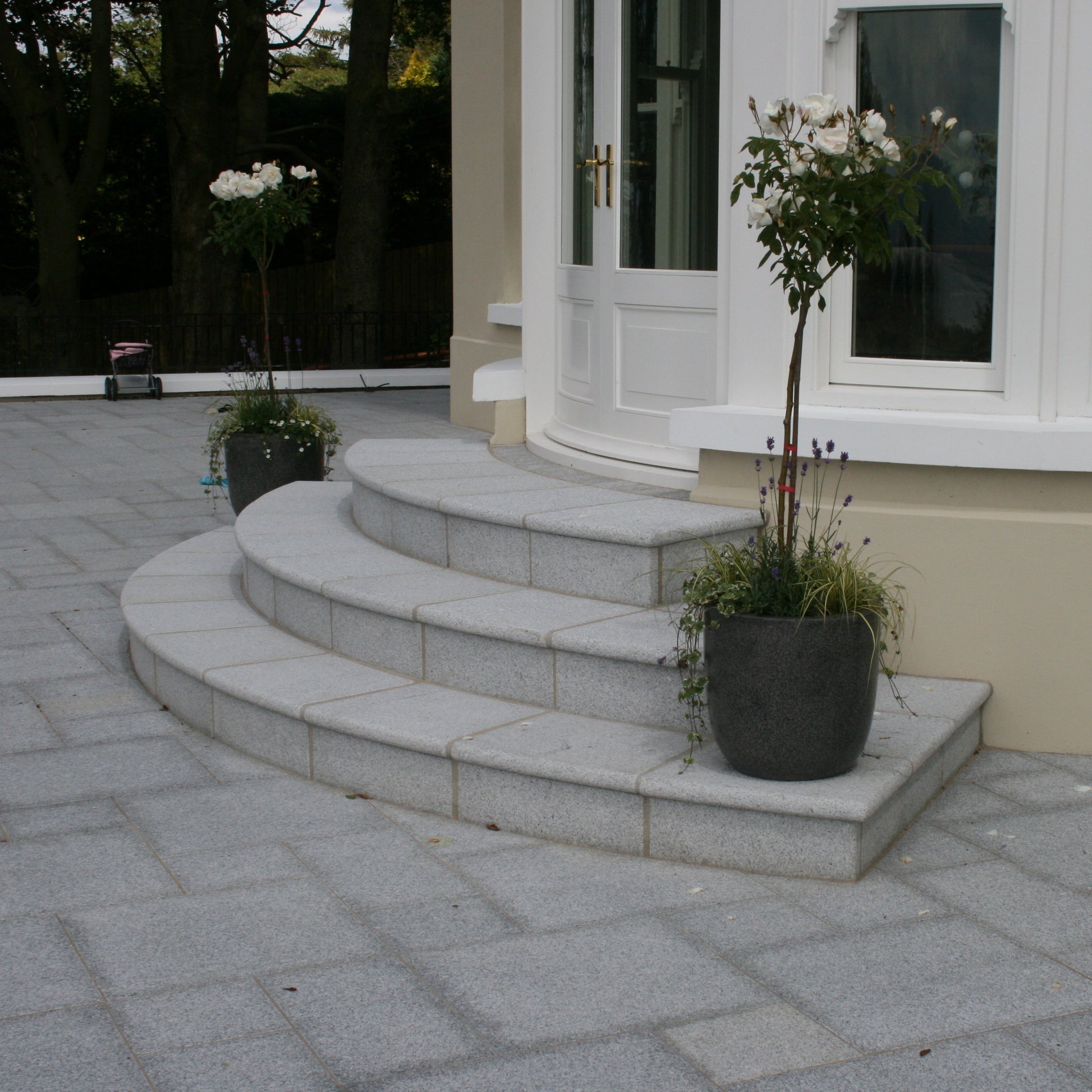 Bespoke Silver Granite Steps with a curved design at conservatory entrance to patio. 