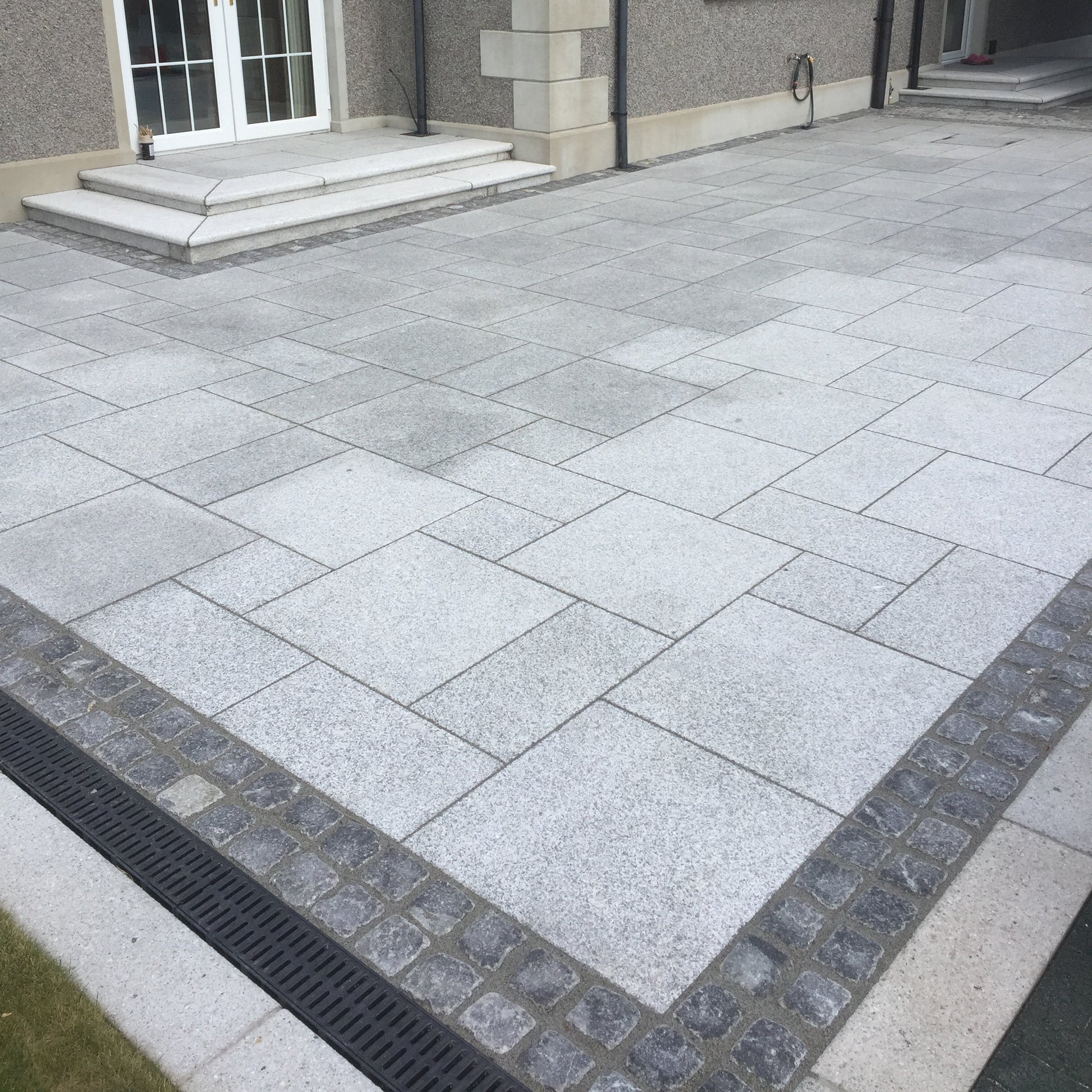 Silver Granite Patio with Black Granite Cobble Double Border in 100 x 100mm size. 