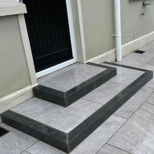 Porcelain steps completed using Black Granite Kerbs. 