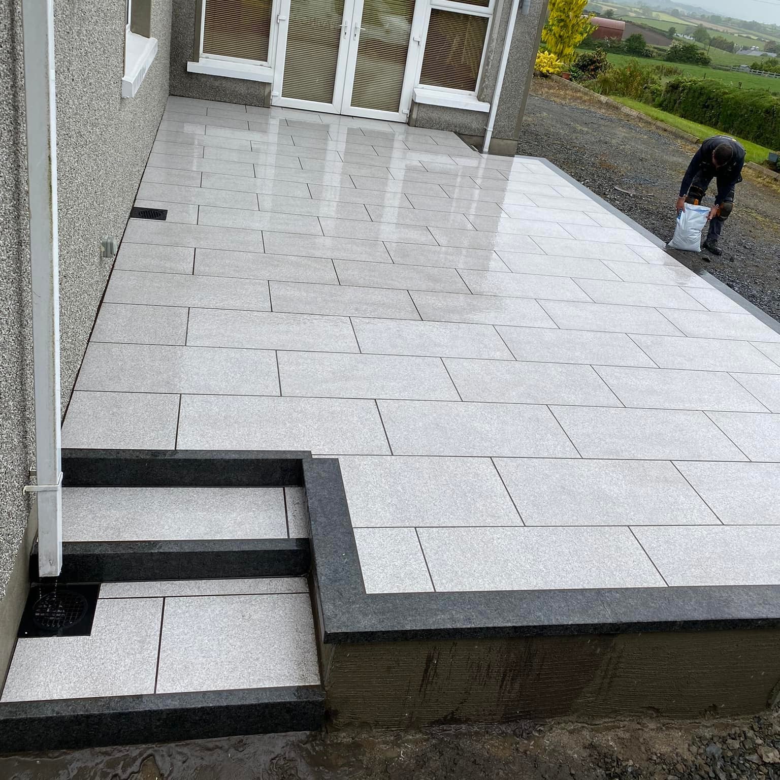 Porcelain patio with steps completed using Black Granite Kerbing.