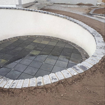 Circular pathway with a sunken patio area. Pathway wall completed using Black Granite Cobbles. 