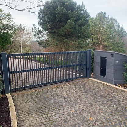 Automated gate with a security shed in a driveway surrounded by trees. Laneway features Black Granite Cobbles in 100 x 100mm size. 