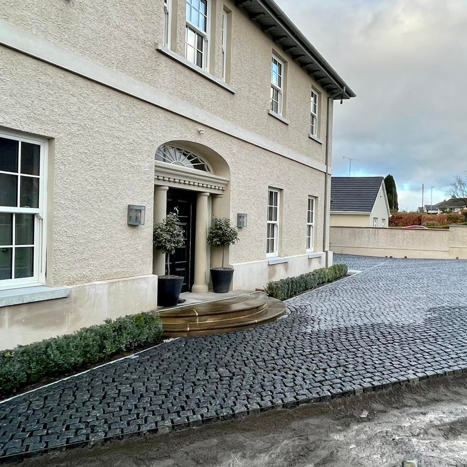 Newly constructed driveway using Black Granite Cobbles in front of a house.