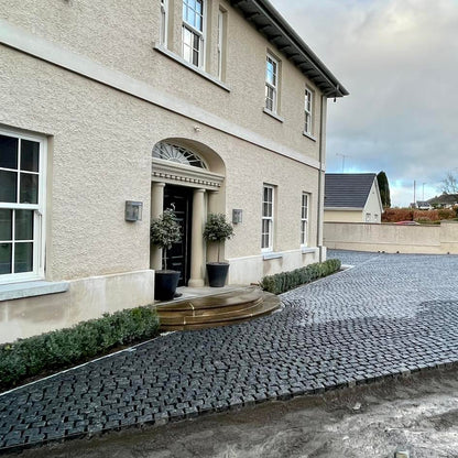 Newly constructed driveway using Black Granite Cobbles in front of a house.