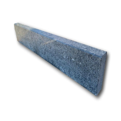 A single black granite pin kerb with a flamed finish, highlighting the textured, rough surface.