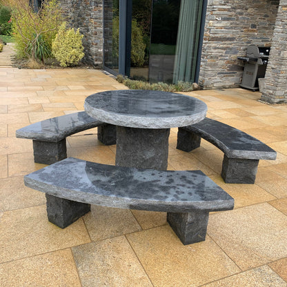 Black Granite picnic table and benches on a gold granite patio with a stone building in the background