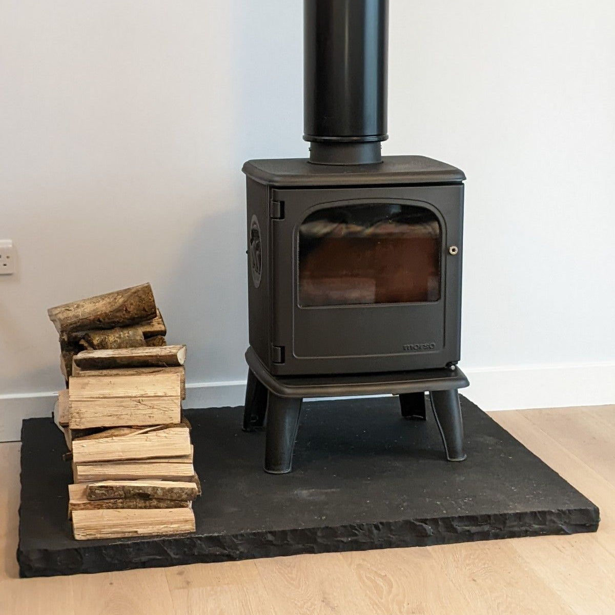 Contemporary Black Limestone Hearth with a Free Standing Stove. 