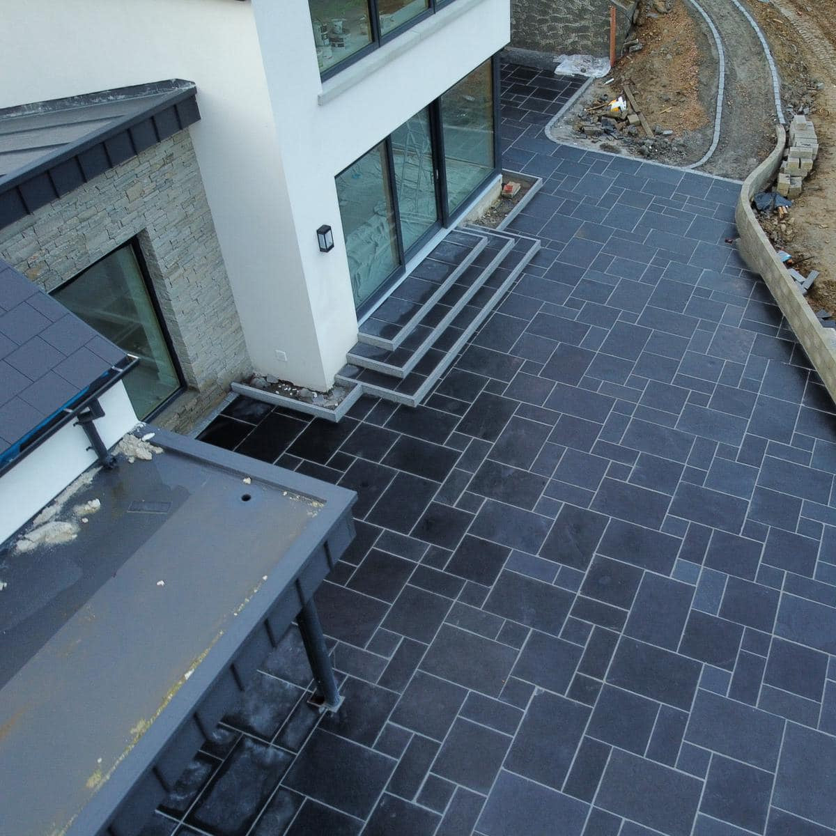 Large contemporary patio area nearing completion with Black Limestone Paving Patio Packs. 