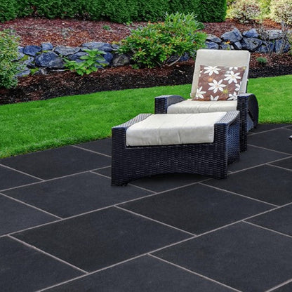 Outdoor patio set with furniture on a black stone patio. Paving is computer generated to show Black Limestone Paving in 600 x 600mm size. 