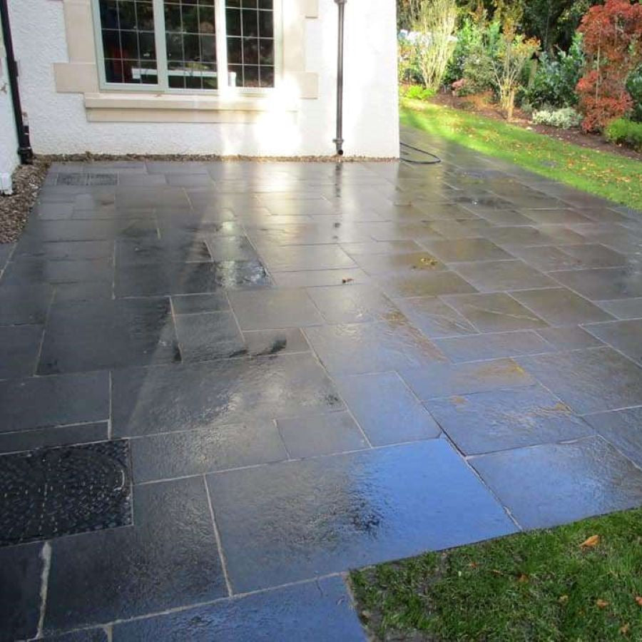 Patio area surrounded by garden completed using Black Limestone Paving in patio pack sizes. 