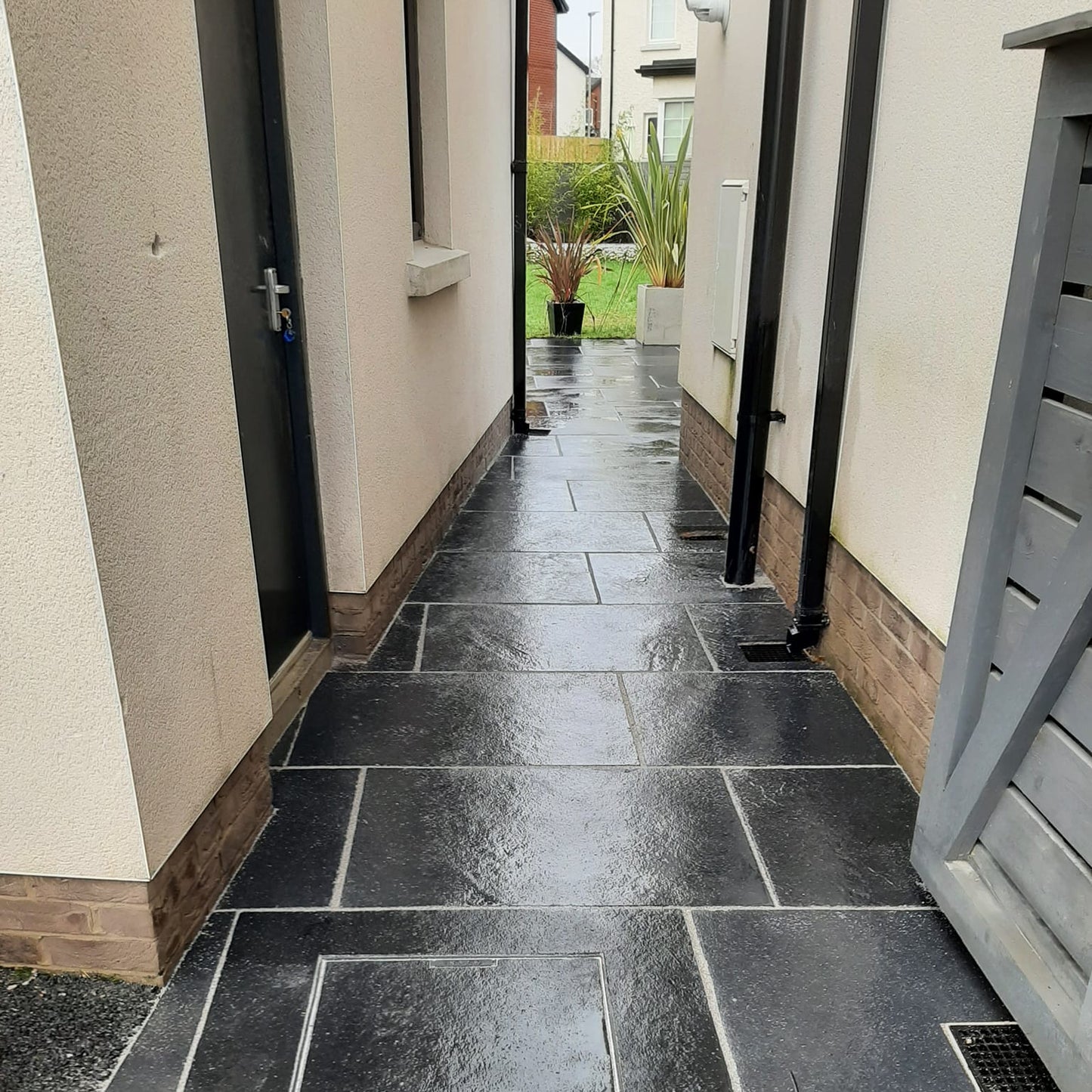 Pathway leading to patio area completed using Black Limestone Paving in 900 x 600mm size.