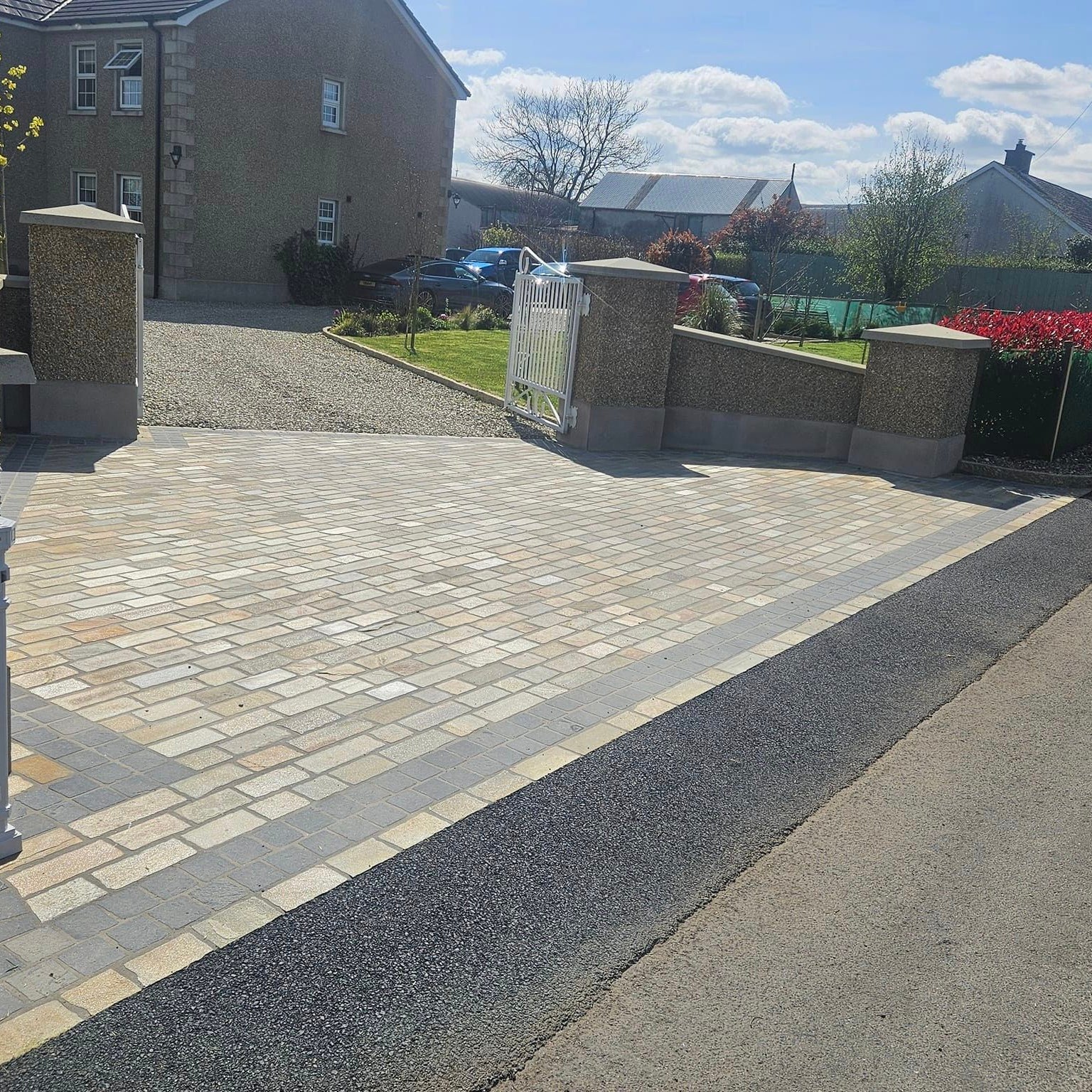 Driveway entrance featuring Donegal Quartzite Cobbles and Black Limestone Cobbles in 100 x 100mm size on a sunny dry day. 