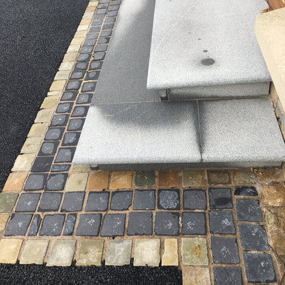 Silver Granite Steps with a mix of stone cobbles in Donegal Quartzite and Black Limestone in 100 x 100mm size. 