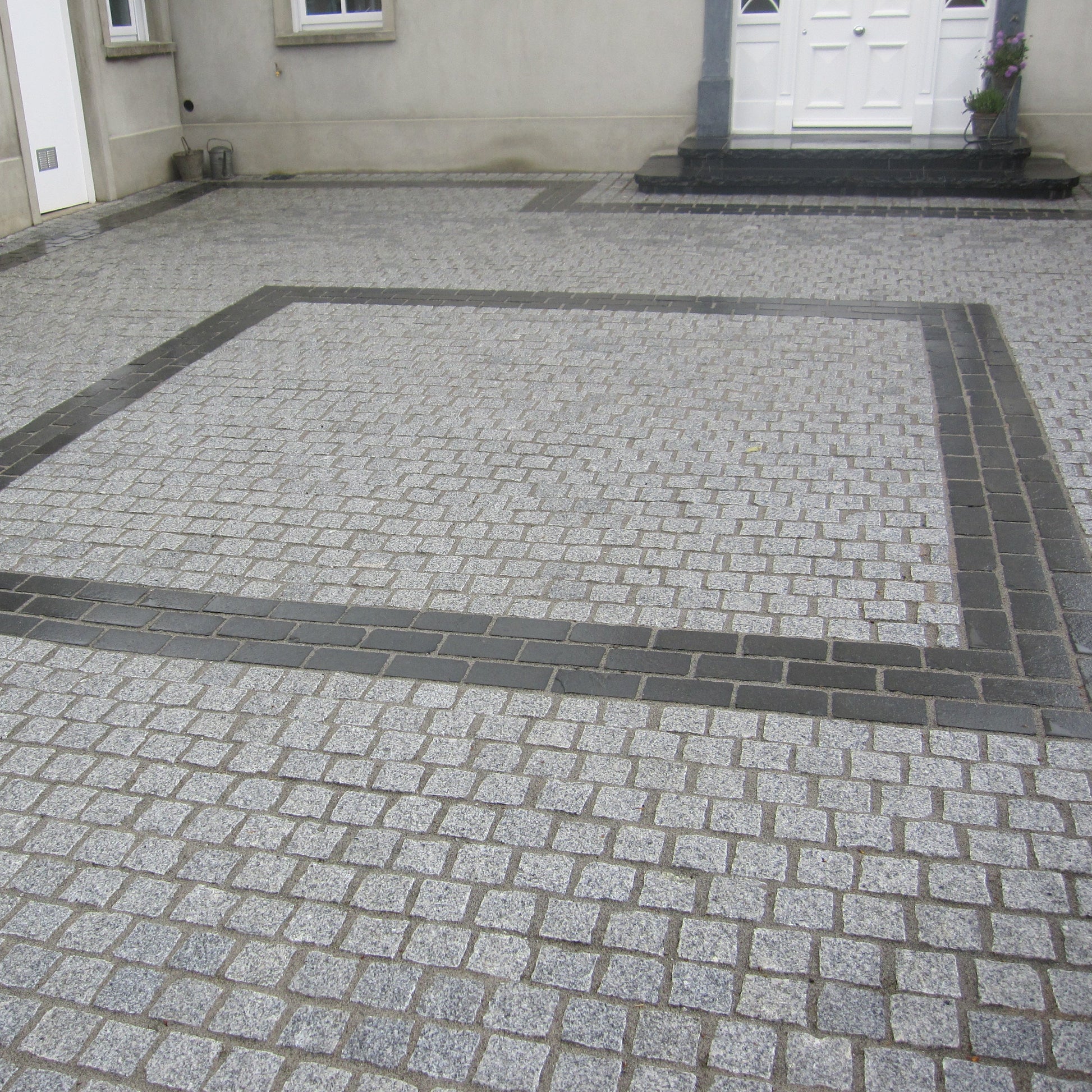 Patio area featuring a square design completed using Black Limestone Paving Cobbles.  