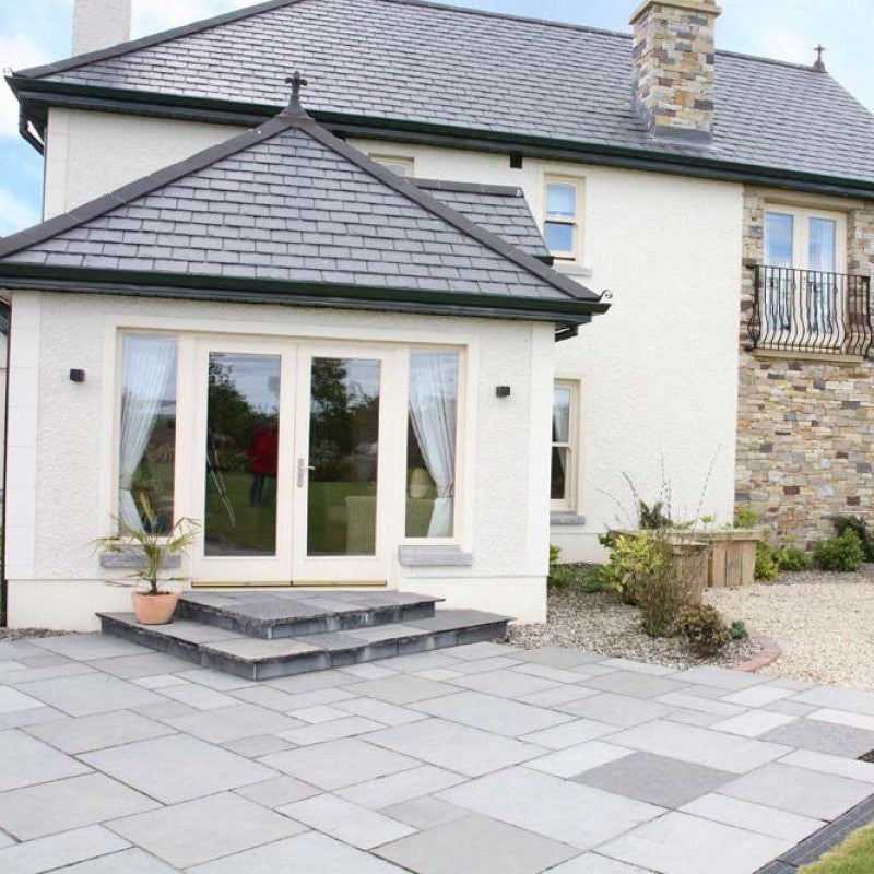 Large two storey house with patio area leading off from the sunroom. Patio completed using Black Limestone Paving in Patio Pack Sizes.  