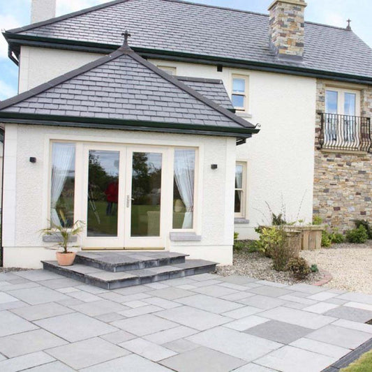 Large two storey house with patio area leading off from the sunroom. Patio completed using Black Limestone Paving in Patio Pack Sizes.  