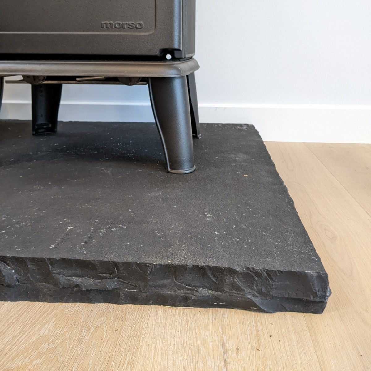 Close up detail of rock face edging finish on a bespoke Black Limestone Hearth