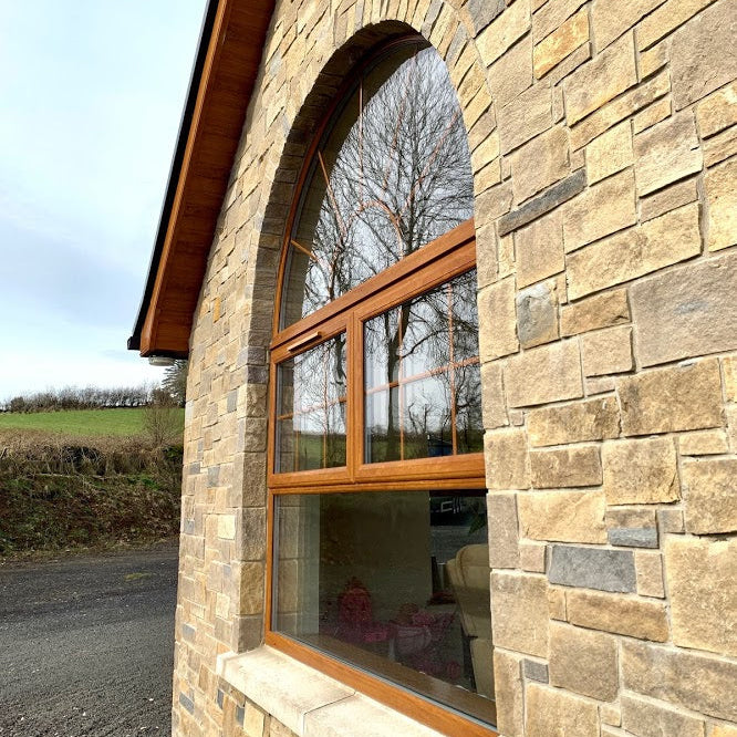 Close up of a stone façade with a window. Stonework in a beautiful mix of Blue Centre Sandstone & Mountcharles Sandstone Stoneer Cladding.