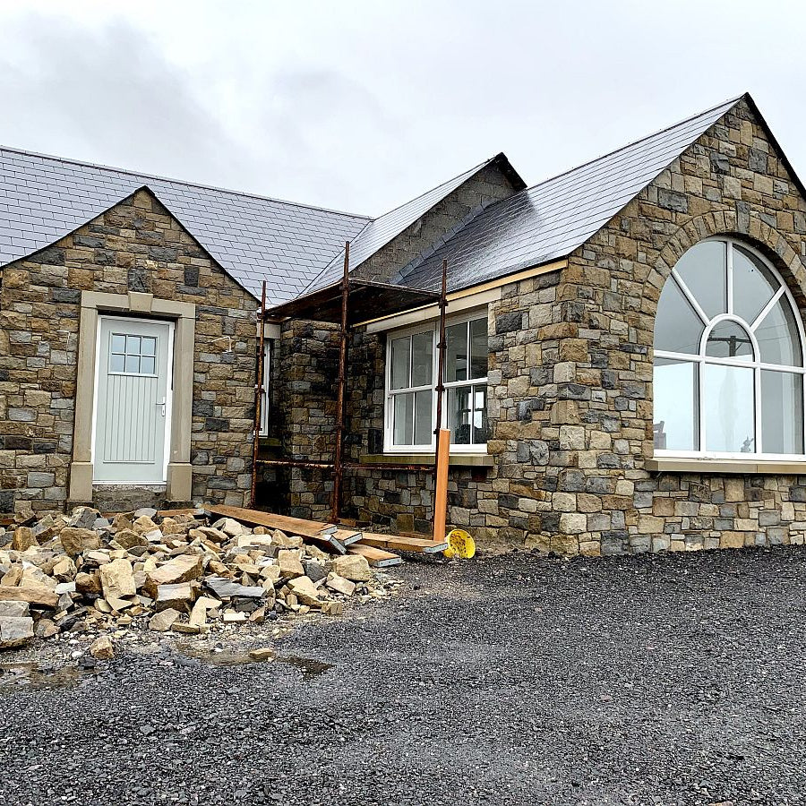 New build under construction with stone walling in Blue Centre Sandstone Machined nearing completion. 