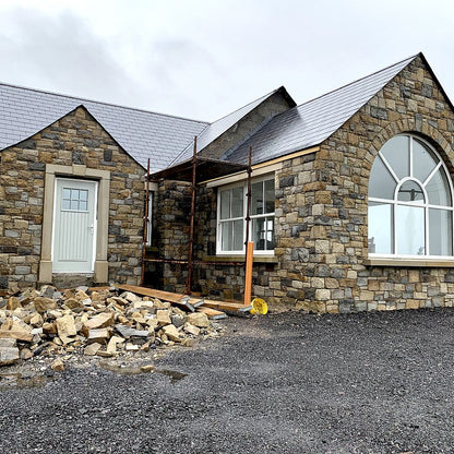 New build under construction with stone walling in Blue Centre Sandstone Machined nearing completion. 