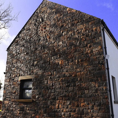 Stone feature wall with small window completed in Blue Centre Sandstone Machined and Sandstone Lintel and Sill. 