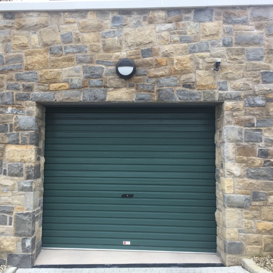 Stone garage with a large door. Stone is Blue Centre Sandstone Machined. 