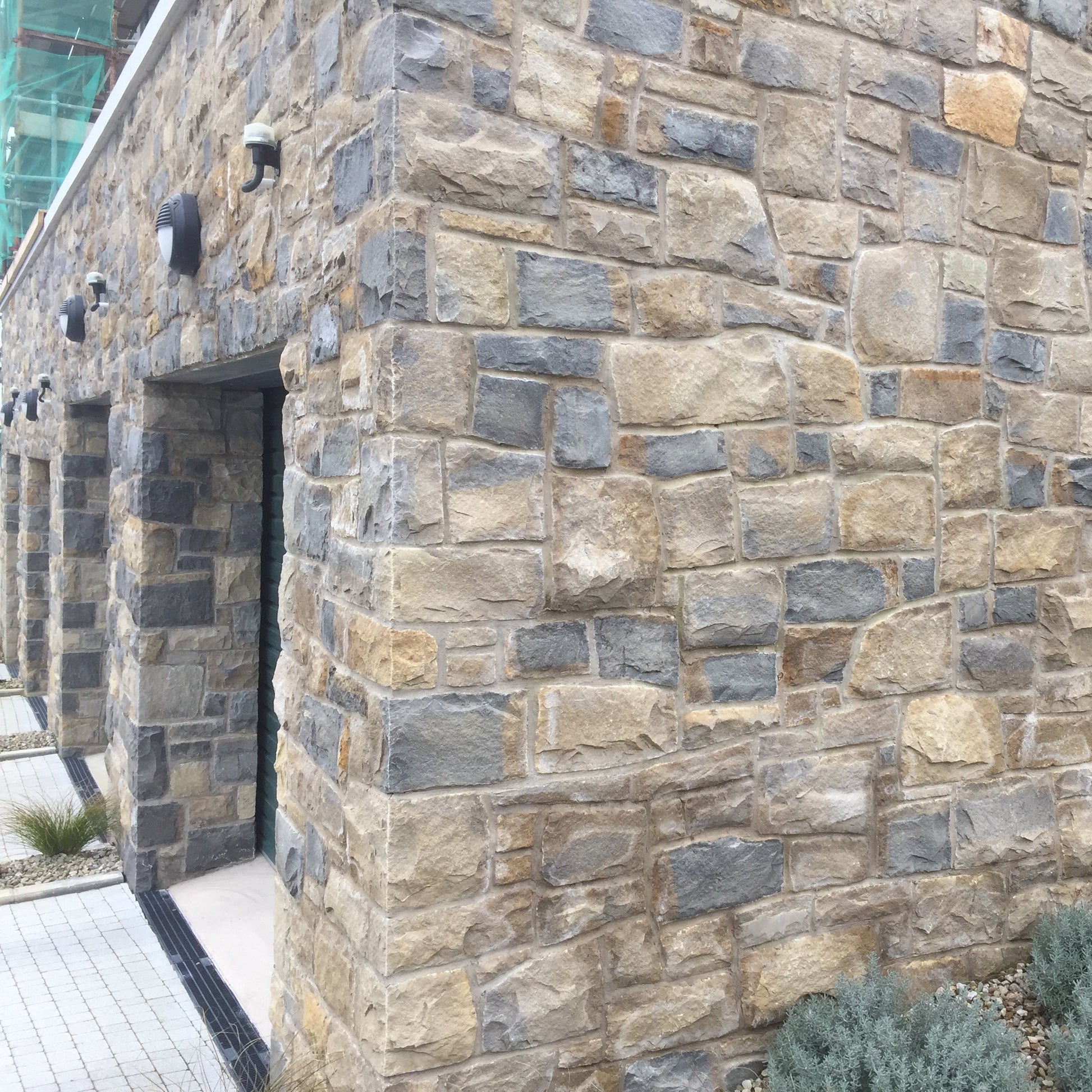 Stone wall of a building completed in Blue Centre Sandstone Machined.
