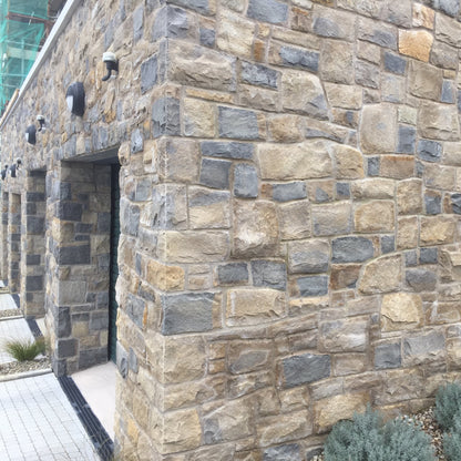 Stone wall of a building completed in Blue Centre Sandstone Machined.
